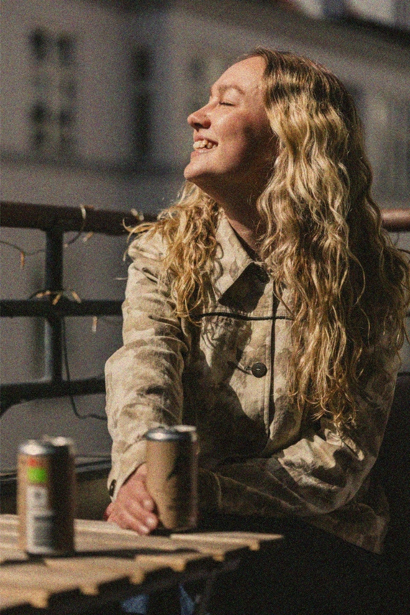 Woman drinking good cola in on a balcony with the sun on her face