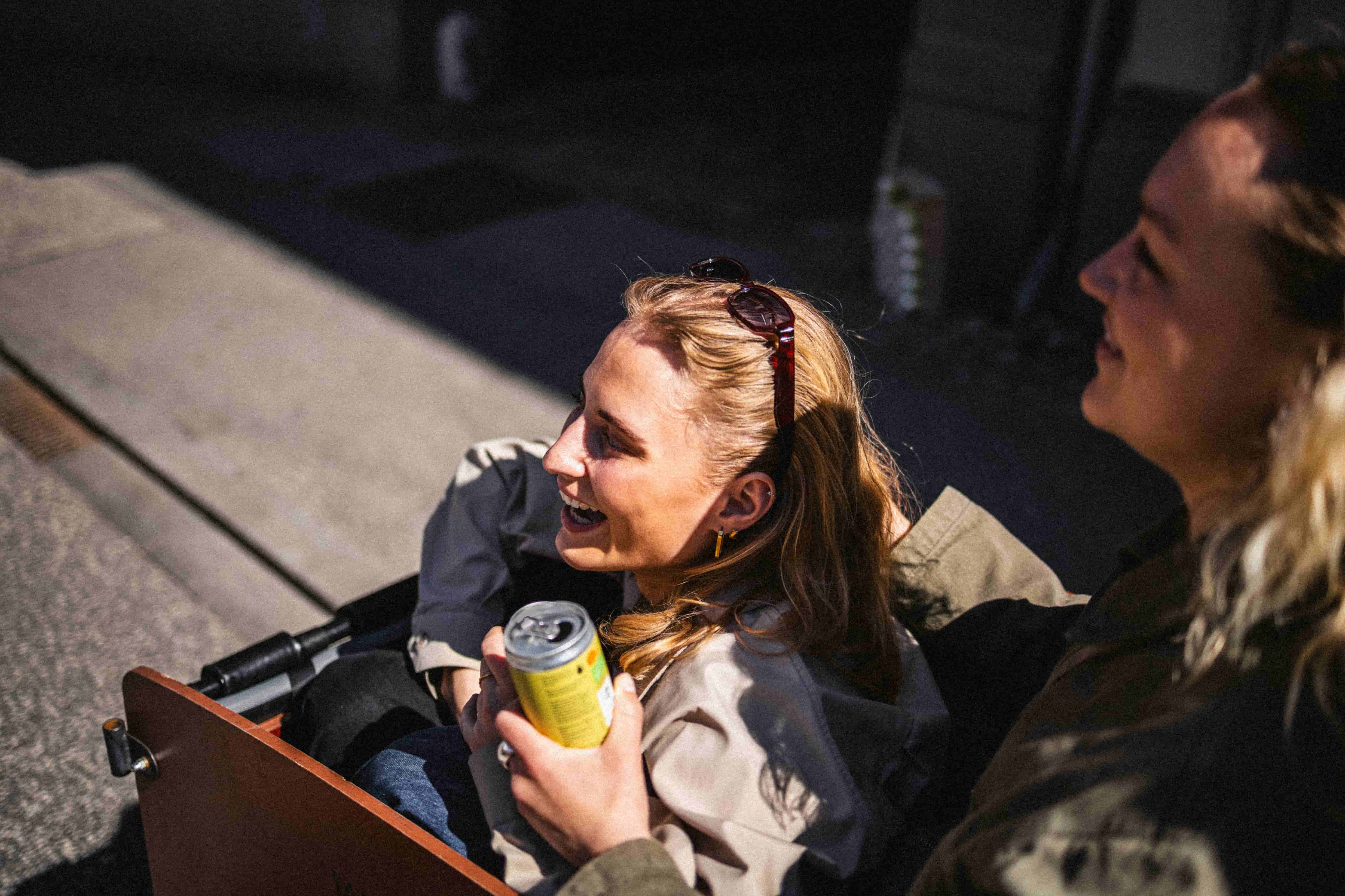 Two women sitting on abike, going through Aarhus City. One has a good lemon in her hand.